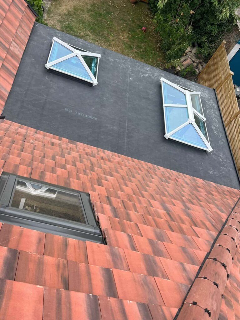 This is a photo taken from the roof ridge looking down a tiled pitched roof on to a flat roof. Works carried out by Kidderminster Roofing Repairs